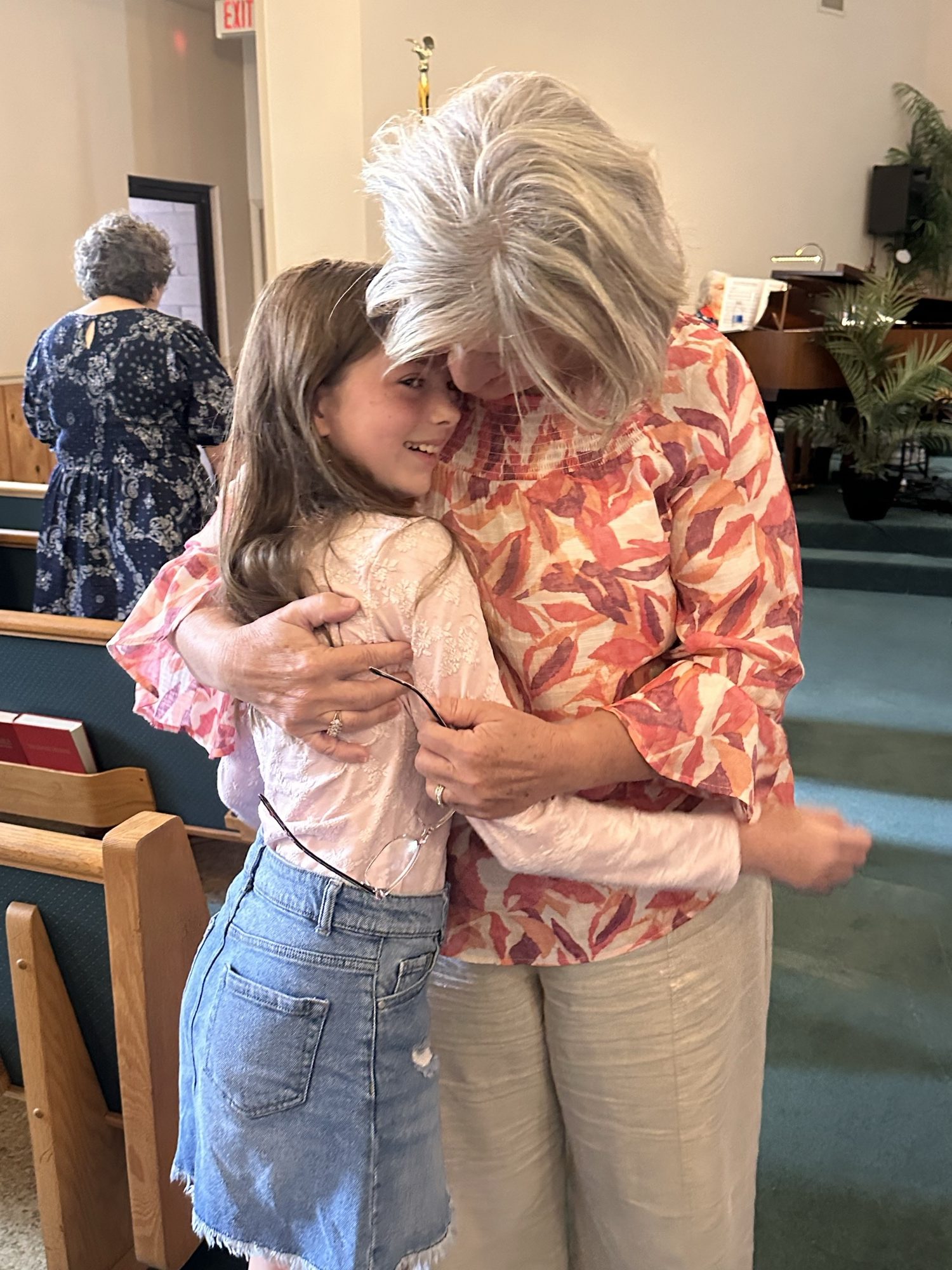 Two women sharing a warm embrace at a women's ministry gathering